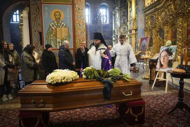 An Orthodox priest prays over a coffin of Ukrainian journalist working for Fox News Oleksandra Kuvshynova, 24, killed by the Russian soldiers, in St. Michael Cathedral in Kyiv, Ukraine, Wednesday, March 20, 2022. Fox News cameraman Pierre Zakrzewski and producer Kuvshynova were killed when their car was struck by the Russian troops in the village of Horenka outside Kyiv last month. (Photo by Efrem Lukatsky/AP Photo)