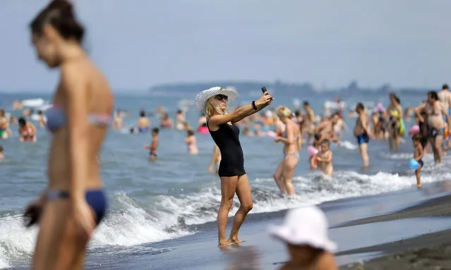 A girl takes a selfie at the Black Sea beach of the seaside resort Ureki, Georgia, 27 July 2015. The Blask Sea resorts are a popular destination for summer vacations. (Photo by Zurab Kurtsikidze/EPA)