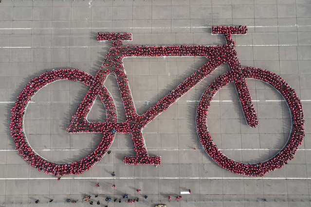 People gather during an attempt to break the Guinness World record for the largest human bicycle on May 27, 2023 in Santiago, Chile. (Photo by Jonnathan Oyarzun/Getty Images)