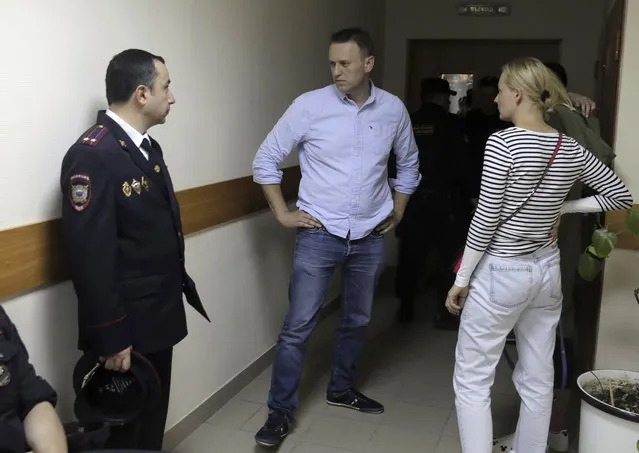 Russian opposition leader Alexei Navalny, center, and his wife Yulia talk before a hearing in a court in Moscow, Russia, on Monday, June 12, 2017. Navalny was arrested earlier this morning at his house when he was going to a protest spearheaded by him. (Photo by Pavel Golovkin/AP Photo)