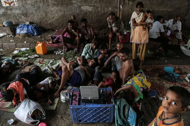 Indian homelss migrant people watch movie on a portable video player on the roadside, Mumbai, India, June 6, 2016. Mumbai has over 57,000 homeless residents, according to the 2011 census. (Photo by Divyakant Solanki/EPA)