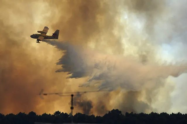 A fire fighting aircraft drops water over a fire outside the village of Pedrogao Grande central Portugal, Monday, June 19, 2017. More than 2,000 firefighters in Portugal battled Monday to contain major wildfires in the central region of the country, where one blaze killed dozens of people, while authorities came under mounting criticism for not doing more to prevent the tragedy. (Photo by Paulo Duarte/AP Photo)