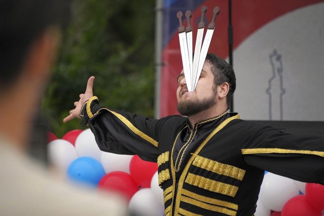 A Caucasian dance ensemble member performs with daggers during celebrations marking National Flag Day, in St. Petersburg, Russia, August 22, 2024. (Photo by Dmitri Lovetsky/AP Photo)