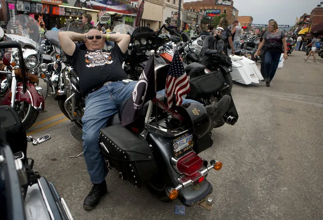 Dave Johnson, of Michigan, takes a break on his bike parked on Main Street while participating in the annual Sturgis Motorcycle Rally in Sturgis, South Dakota, August 4, 2015. (Photo by Kristina Barker/Reuters)