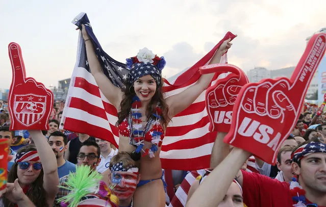 A U.S. soccer fan holds a representation of her country's flag as fans wait for the start of the World Cup round of 16 match against Belgium on a live telecast inside the FIFA Fan Fest area on Copacabana beach in Rio de Janeiro, Brazil, Tuesday, July 1, 2014. (Photo by Leo Correa/AP Photo)