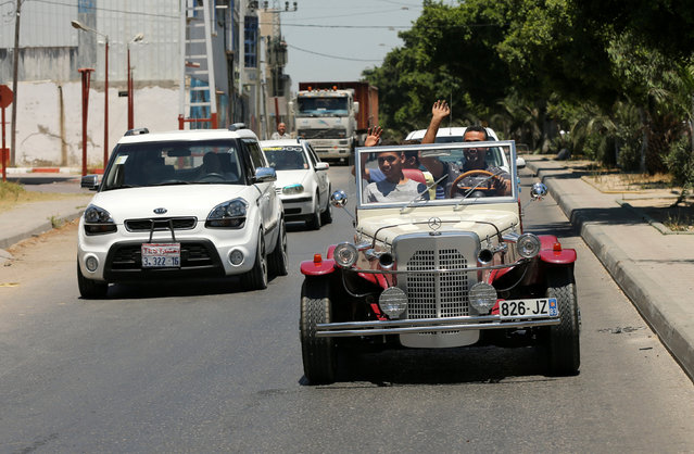 Palestinian Munir Shindi, 36, waves as he drives a replica of a 1927 Mercedes Gazelle that he built from scratch, on a street in Gaza City June 19, 2016. (Photo by Mohammed Salem/Reuters)