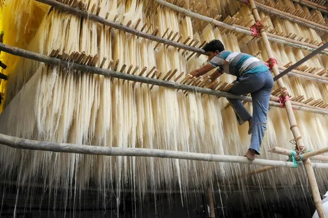 A worker spreading Sewaiyan (Vermicelli) for drying at a factory, June 22, 2016, in Bhopal, India. Sewaiyan production is in full flow to met huge demand due to ongoing Ramzan and coming Eid festival. (Photo by Mujeeb Faruqui/Hindustan Times/Getty Images)