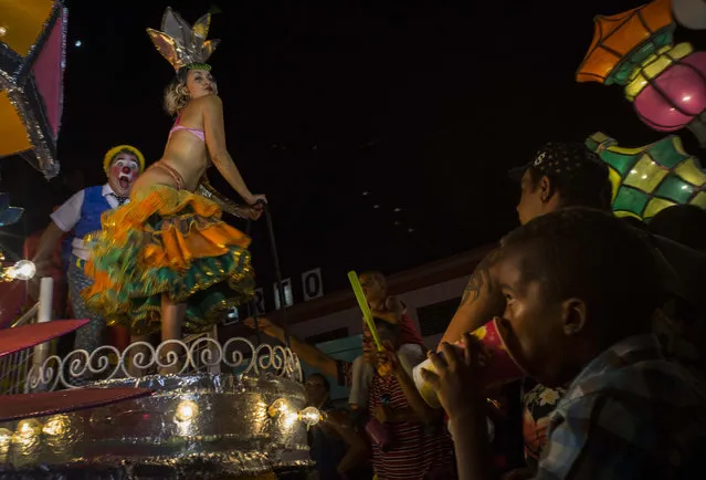 In this July 25, 2015 photo, revelers parade during carnival celebrations in Santiago, Cuba. Cuban cities are seeing stagnant visitor numbers despite the dramatic surge in overall tourism set off by the announcement of detente between the U.S. and Cuba. (Photo by Ramon Espinosa/AP Photo)