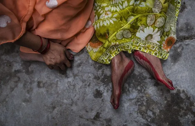 A relative (L) of Champa Devi, 88, sits next to her body, minutes after her death at Mukti Bhavan (Salvation House) at Varanasi, in the northern Indian state of Uttar Pradesh, June 21, 2014. (Photo by Danish Siddiqui/Reuters)