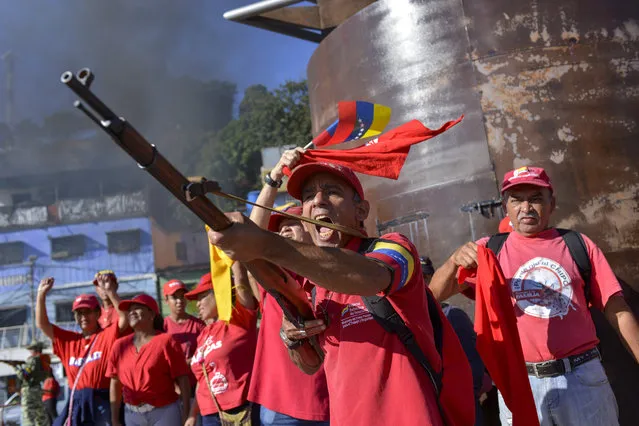 A member of the Bolivarian National Militia brandishes a rifle during an invasion drill in Caracas, Venezuela, Saturday, February 15, 2020. Venezuela's President Nicolas Maduro ordered two days of nationwide military exercises, including participation of civilian militias. (Photo by Matias Delacroix/AP Photo)