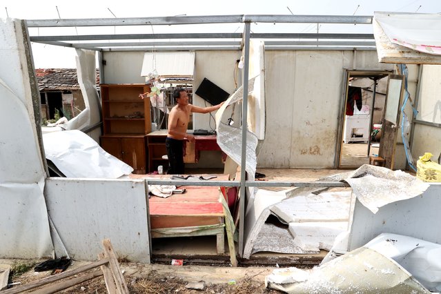 A villager searches for recoverable items in a heavily damaged home following a tornado on July 21, 2022 in Guanyun County, Lianyungang City, Jiangsu Province of China. A tornado struck east China's Jiangsu province on Wednesday, killing one person and injuring 25 others. (Photo by Geng Yuhe/VCG via Getty Images)