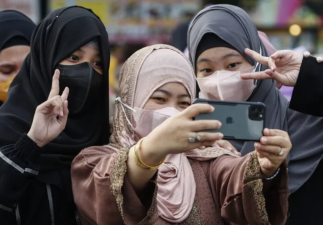 Muslims take selfies after conducting morning prayers to mark Eid al-Adha at the Quezon Memorial Circle in Quezon City, Metro Manila, Philippines, 09 July 2022. Eid al-Adha is the holiest of the two Muslim holidays celebrated each year. It marks the yearly Muslim pilgrimage of Hajj to visit Mecca, the holiest place in Islam. (Photo by Rolex Dela Pena/EPA/EFE)