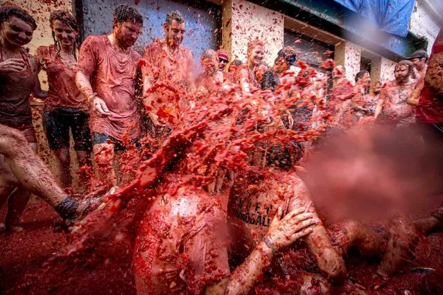Revellers throw tomato pulp at each other during the annual “Tomatina” festivities in the village of Bunol, near Valencia on August 26, 2015. (Photo by Biel Alino/AFP Photo)