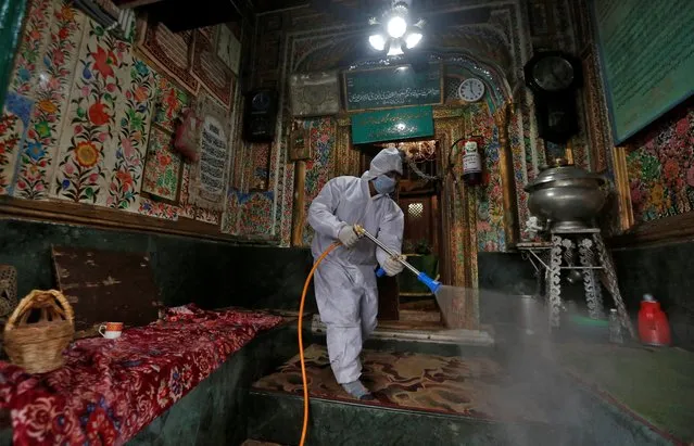 A municipal worker wearing a protective suit disinfects the shrine of Sufi Saint Khawaja Naqashband as a preventive measure against the spread of coronavirus disease (COVID-19), in Srinagar March 19, 2020. (Photo by Danish Ismail/Reuters)
