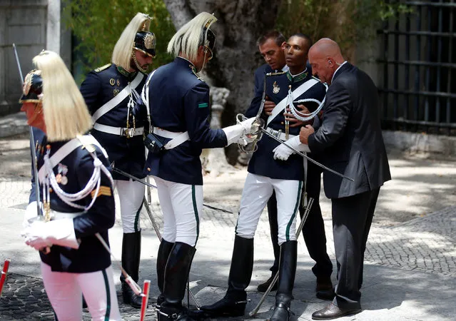 A member of the guard of honor is attended by colleagues after fainting before the arrival of French President Francois Hollande at the Belem Palace in Lisbon, Portugal, July 19, 2016. (Photo by Rafael Marchante/Reuters)