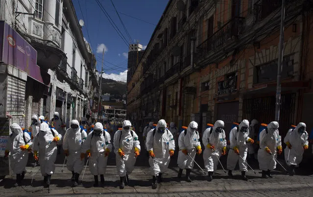 City workers fumigate a street to help contain the spread of the new coronavirus in La Paz, Bolivia, Thursday, April 2, 2020. (Photo by Juan Karita/AP Photo)