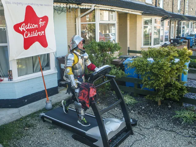 Mike Manders uses a treadmill in his front garden dressed in a suit of armour as he attempts the postponed Hull 10k, as the UK continues its lockdown to help curb the spread of coronavirus, in Hull, England, Sunday April 19, 2020. Manders has shed 5 stone in the past year – the same amount of weight as the armour – and is raising money for children's charity Action for Children and is live streaming the run on FaceBook. (Photo by Danny Lawson/PA Wire via AP Photo)