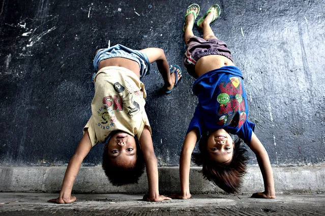 Children display their acrobatic skills at an underpass in Manila on August 28, 2014 near where informal settlers' homes were recently demolished. (Photo by Noel Celis/AFP Photo)