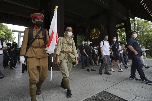 Visitors in old Japanese Imperial army uniforms enter Yasukuni Shrine, which honors Japan's war dead, Monday, August 15, 2022, in Tokyo. Japan marked the 77th anniversary of its World War II defeat Monday. (Photo by Eugene Hoshiko/AP Photo)