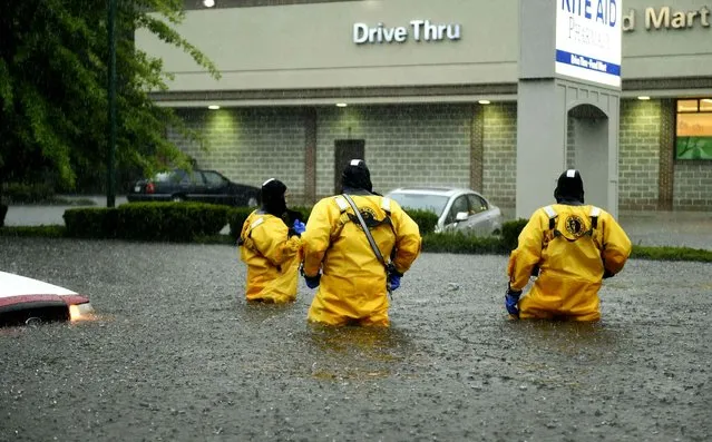 Firefighters wade through floodwaters as flash flooding swamped a street after a heavy thunderstorm moved through New London, Conn., Thursday, September 10, 2015. (Photo by Sean D. Elliot /The Day via AP Photo)