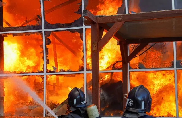 Firefighters work to extinguish fire at the shopping mall Galaktika following recent shelling in the course of Ukraine-Russia conflict in Donetsk, Ukraine on August 24, 2022. (Photo by Alexander Ermochenko/Reuters)