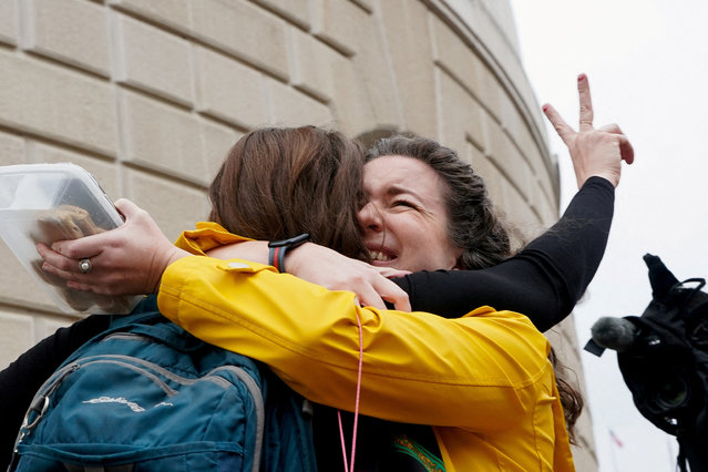 Terminated U.S. Agency for International Development (USAID) employee Caitlin Harwood gestures as she hugs her cousin Samantha Kent after laid-off USAID workers cleared out their desks and collected personal belongings, during a sendoff in Washington, D.C., U.S., February 27, 2025. (Photo by Nathan Howard/Reuters)