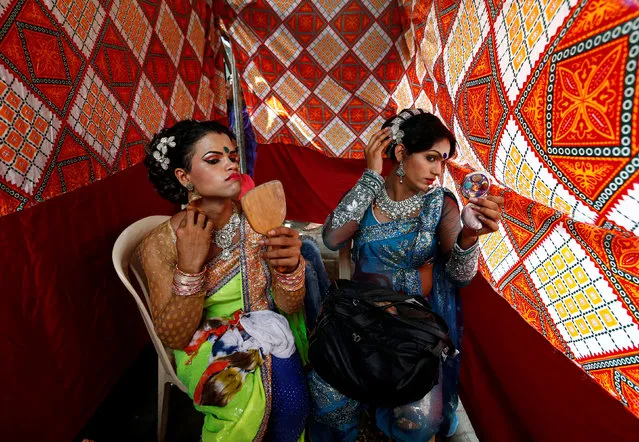 Eunuchs apply make-up before Raksha Bandhan festival celebrations in a red light area in Mumbai, India, August 17, 2016. (Photo by Danish Siddiqui/Reuters)