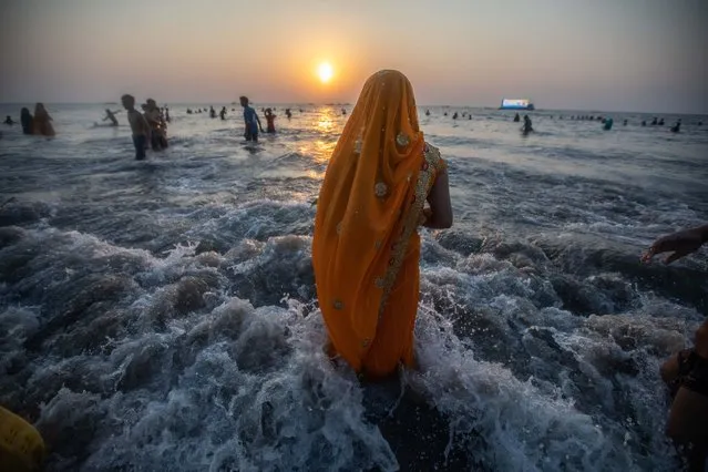 Hindu devotees perform a ritual while offering prayers to the Sun God on the occasion of the Hindu festival “Chhath Puja”, at Juhu beach, in Mumbai, India, 30 October 2022. Chhath Puja is an ancient Hindu festival dedicated to Surya, the Hindu Sun God, also known as Surya Shashti. The Sun, considered the god of energy and the life force, is worshiped during the Chhath festival to promote well-being, prosperity, and progress. (Photo by Divyakant Solanki/EPA/EFE)