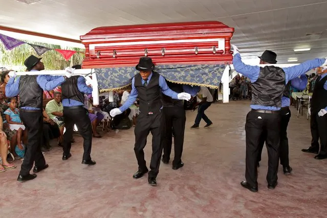 Pallbearers from one of the Surinamese capital's cemeteries dance and sing with a casket during a competition for best performing pallbearers group at the Hodie Mi Cras Tibi funeral hall in Paramaribo, September 20, 2015. One of the cemeteries decided to celebrate their annual pallbearers day with something different – a song and dance contest. (Photo by Ranu Abhelakh/Reuters)