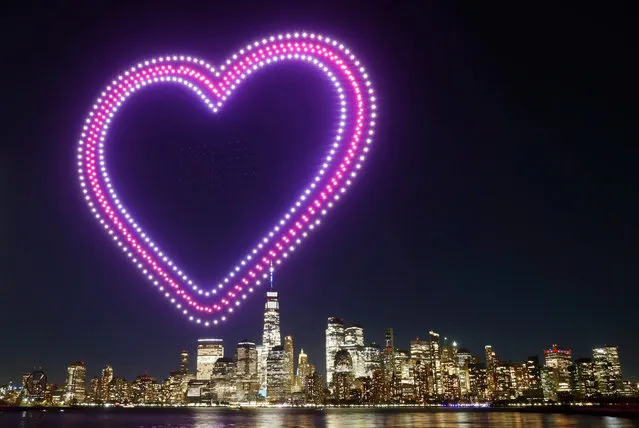 A heart is created by 500 drones over the skyline of lower Manhattan and One World Trade Center during an advertising promotion for the 10th anniversary of the video game Candy Crush Saga in New York City on November 3, 2022, as seen from Jersey City, New Jersey. (Photo by Gary Hershorn/Getty Images)