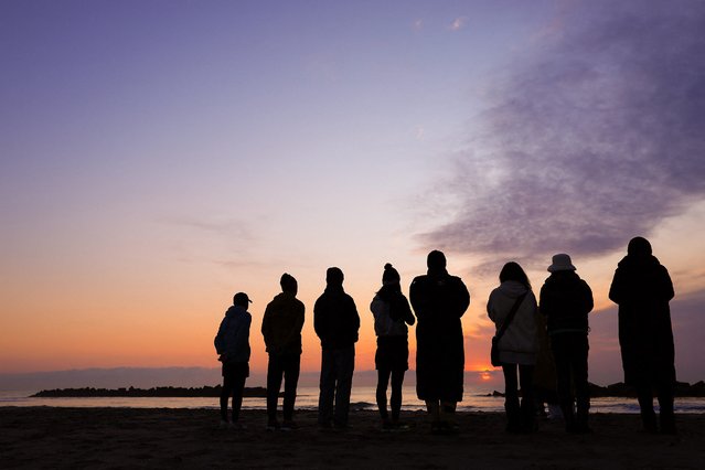 People watch the sunrise at the beach in Sendai's Wakabayashi Ward, Miyagi Prefecture on March 11, 2025, on the 14th anniversary of the magnitude 9.0 earthquake which triggered a tsunami and nuclear disaster. (Photo by JIJI Press/AFP Photo)