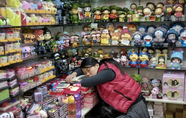 A vendor sleeps at a shop in Beijing, in this November 17, 2013 file photo. Small and medium enterprises (SMEs) are already the heart of China's economy, providing 80 percent of urban employment and 60 percent of GDP. But the country's financial infrastructure is largely geared to state firms. So although China has announced a volley of rate cuts to stabilise its battered stock market and reverse a slowdown in growth, SMEs are experiencing little or no benefit, underlining concerns about the world's second-biggest economy. (Photo by Jason Lee/Reuters)