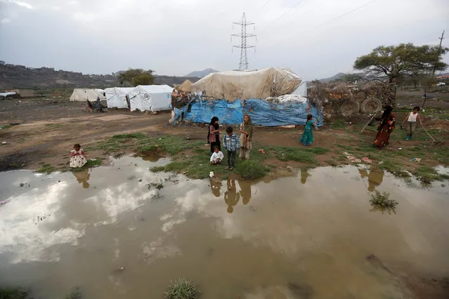 Children play near a rain water at a camp for internally displaced people near Sanaa, Yemen, August 10, 2016. (Photo by Khaled Abdullah/Reuters)