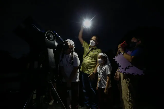 A family takes turns to view phases of a total lunar eclipse through a telescope at a university campus in Quezon City, Metro Manila, Philippines, 08 November 2022. The next total lunar eclipse is expected to occur in March 2025. (Photo by Rolex Dela Pena/EPA/EFE/Rex Features/Shutterstock)