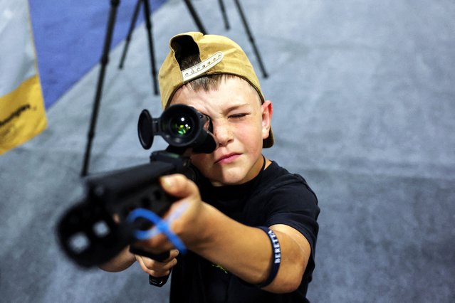 A boy holds a gun at a booth during the NRA annual meeting in Atlanta, Georgia, U.S. April 26, 2025. (Photo by Jeenah Moon/Reuters)