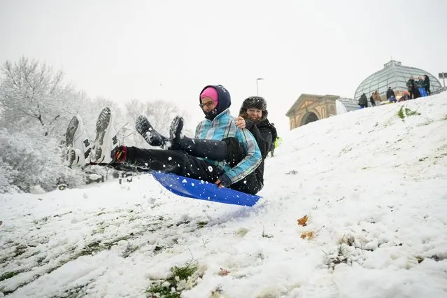 Two friends take to the air after hitting a ramp while sledging in Alexandra Park on December 12, 2022 in London, England. Snow and ice disrupted rail travel and closed schools in parts of southeast England on Monday. (Photo by Leon Neal/Getty Images)