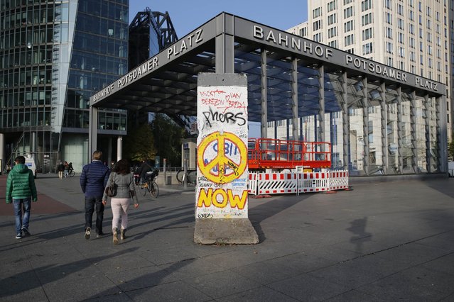 People walk past a segment of the former Berlin Wall at Potsdamer Platz square in Berlin October 29, 2014. (Photo by Fabrizio Bensch/Reuters)
