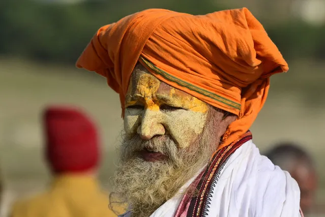A Sadhu or a Hindu holyman arrivesfor the land allotment of temporary tents at the “Sangam”, the confluence of the rivers Ganges, Yamuna, and mythical Saraswati ahead of the 'Magh Mela' festival in Prayagraj on December 14, 2022. (Photo by Sanjay Kanojia/AFP Photo)