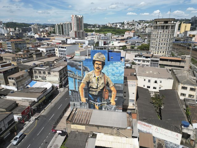 A mural depicting a steel worker adorns an office building near the Companhia Siderurgica Nacional or National Steel Company, in Volta Redonda, Tuesday, February 11, 2025. (Photo by Mario Lobao/AP Photo)