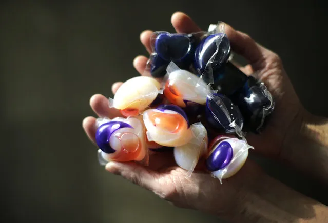 In this photo taken Friday, November 7, 2014, laundry detergent packets are held for a photo, in Chicago. Accidental poisonings from squishy laundry detergent packets sometimes mistaken for toys or candy landed more than 700 U.S. children in the hospital in just two years, researchers report. Coma and seizures were among the most serious complications. (Photo by Charles Rex Arbogast/AP Photo)