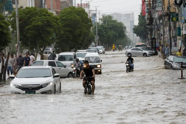 Commuters ride past a flooded street during the monsoon rain, as the outbreak of the coronavirus disease (COVID-19) continues, in Karachi, Pakistan on August 25, 2020. (Photo by Akhtar Soomro/Reuters)