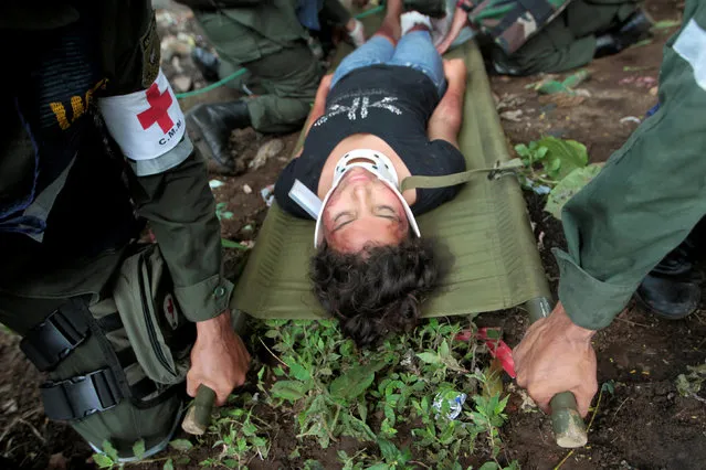 Nicaraguan army members carry a participant playing the role of a victim during a national multi-hazard drill organized by the National System for Prevention, Mitigation and Attention to Disasters (SINAPRED), in the 30 de Mayo neighborhood in Managua, Nicaragua, September 26, 2016. (Photo by Oswaldo Rivas/Reuters)