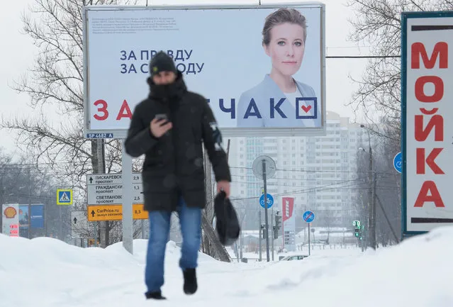 A man walks near a board, which advertises the campaign of Russian TV personality and presidential candidate Ksenia Sobchak, on a street in St. Petersburg, Russia February 19, 2018. (Photo by Anton Vaganov/Reuters)