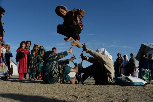 In this photograph taken on December 23, 2017 Afghan school children play at an open-air school at the Gambiri Refugee Camp in Laghman province. Millions of dollars have been spent on the education sector in Afghanistan, but there are countless schools across the country that are in the same predicament – either in tents or in the open air. (Photo by /AFP Photo)