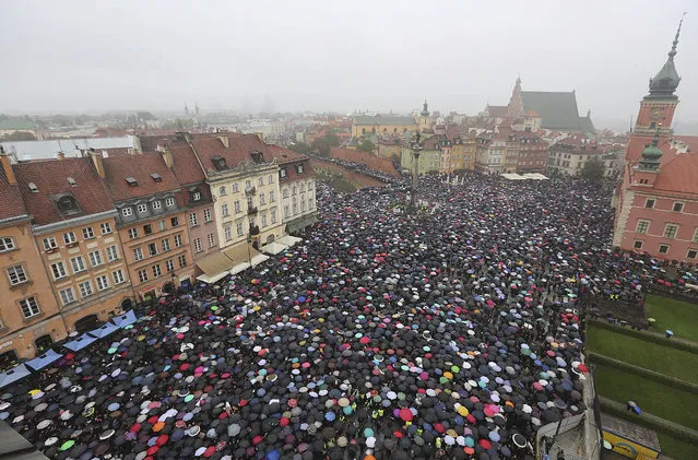A sea of thousands of umbrellas of women and men participating in a nationwide “Black Monday” strike to protest a legislative proposal for a total ban on abortion, in downtown Castle Square is pictured in Warsaw, Poland, Monday, October 3, 2016. Massive protests were held in the rain in the streets of Warsaw, Gdansk, Wroclaw and elsewhere across the largely Catholic nation led by a conservative government. (Photo by Czarek Sokolowski/AP Photo)