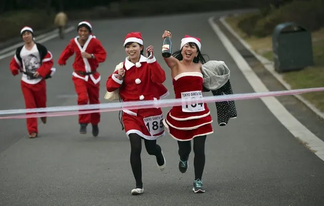 Participants in Santa Claus costume approach to finish during Santa Run at Kasai Rinkai Park in Tokyo, Saturday, December 6, 2014. Over 400 people participated in the 2.5 kilometer-run (1.5 miles). (Photo by Eugene Hoshiko/AP Photo)