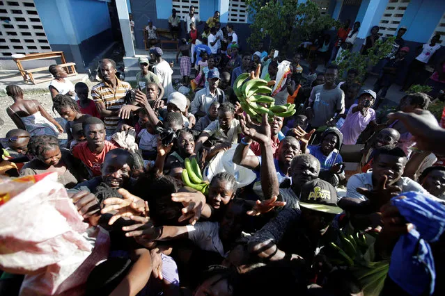 Residents at a shelter in the school Liliane Mars Dumarsais Estime fight for food during a delivery after Hurricane Matthew in Les Cayes, Haiti, October 7, 2016. (Photo by Andres Martinez Casares/Reuters)