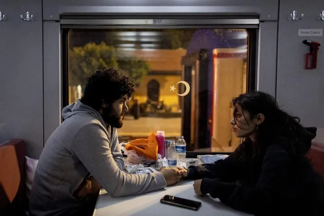 Yusuf Kurma, 20, and Aysel Ozcelik, 20, sit holding hands in one of the carriages at Iskenderun train station, as they talk about their upcoming marriage, in Iskenderun, Turkey on February 18, 2023. The couple, who planned to marry, ran to find each other after the first shock. Now they might postpone the wedding. “We can't have a wedding when we have so many dead”, Ozcelik said. (Photo by Eloisa Lopez/Reuters)