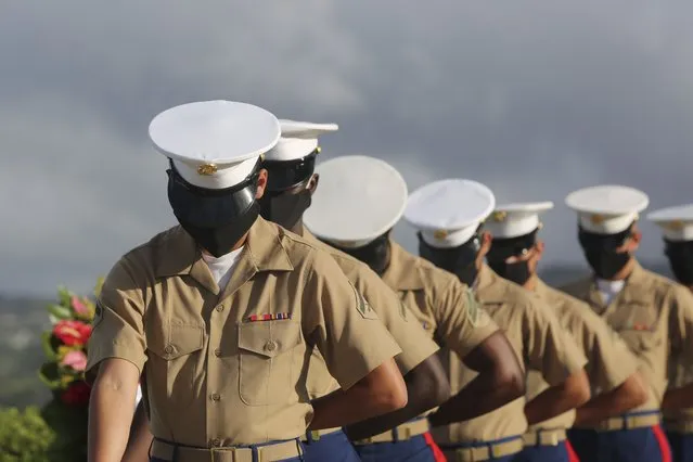 U.S. Marines wearing masks pause during a prayer at a ceremony marking the attack on Pearl Harbor, Monday, December 7, 2020, in Pearl Harbor, Hawaii. Officials gathered in Pearl Harbor to remember those killed in the 1941 Japanese attack, but public health measures adopted because of the coronavirus pandemic meant no survivors were present. The military broadcast video of the ceremony live online for survivors and members of the public to watch from afar. A moment of silence was held at 7:55 a.m., the same time the attack began 79 years ago. (Photo by Caleb Jones/AP Photo/Pool)