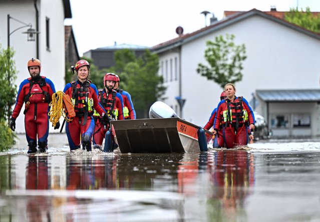 Rescue forces pull a boat on a flooded street in Baar-Ebenhausen on June 2, 2024. Heavy rains from May 31, 2024 onwards have led to flooding across the southern German states of Baden-Wuerttemberg and Bavaria. (Photo by (Lukas Barth/AFP Photo)